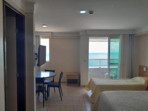 Habitación de hotel con 2 camas y mesa con vistas en Quarto em condomínio beira-mar en Recife
