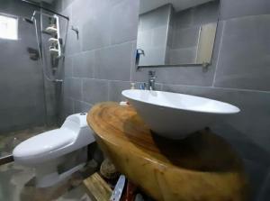 a bathroom with a wooden sink and a toilet at MY CASA BLANCA JF in Galapa