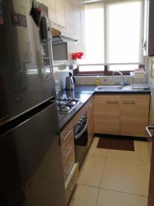 a kitchen with a stainless steel stove and a window at Rent apartment Viña del Mar in Viña del Mar
