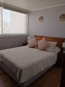 a bedroom with a bed with two pillows and a window at Rent apartment Viña del Mar in Viña del Mar