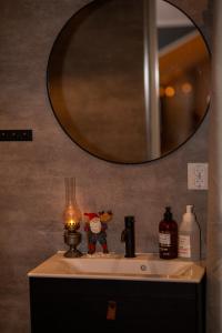 um lavatório de casa de banho com um candeeiro e um espelho em Mysig lägenhet med öppen planlösning på hästgård. em Ljung