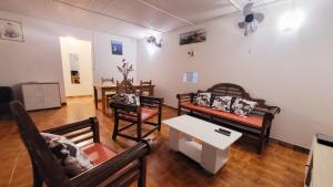 a living room with chairs and a couch and a table at Villa Majorelia in Vieux-Habitants