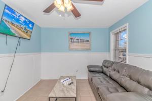 uma sala de estar com um sofá e uma ventoinha de tecto em 125 Atlantic Avenue Unit F - Pet Friendly! Walk To The Beach and Pier! 1BR -1BA - Sleeps 2-4 guests! em Myrtle Beach