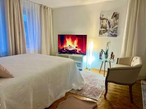 1 dormitorio con 1 cama, TV y silla en Louis & Elza Old Town Romantic apartments, en Wroclaw