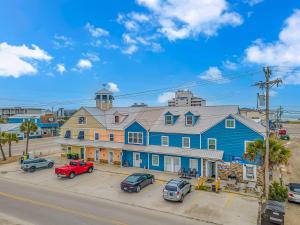 Una gran casa azul con coches estacionados frente a ella en 125 Atlantic Avenue Unit E - Pet Friendly! Walk To The Beach and Pier!1BR -1BA - Sleeps 2-4 guests!, en Myrtle Beach