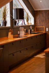 a kitchen with a counter top and some plants at Mysig lägenhet med öppen planlösning på hästgård. in Ljung