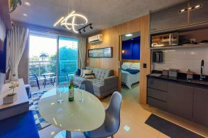 a kitchen and living room with a white table and chairs at One Milenio - Luxuoso e Moderno Studio no Cocó in Fortaleza