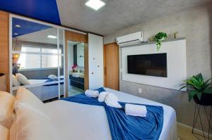 a bedroom with two beds and a flat screen tv at One Milenio - Luxuoso e Moderno Studio no Cocó in Fortaleza