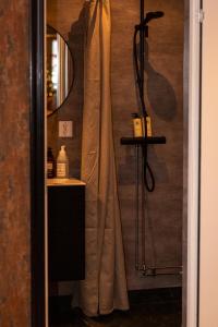 een douche met een douchegordijn in de badkamer bij Mysig lägenhet med öppen planlösning på hästgård. in Ljung