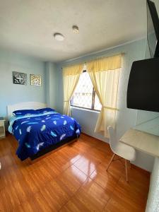 1 dormitorio con cama, escritorio y ventana en Hostal Brilliant en Quito