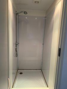 La salle de bains est pourvue d'une douche avec une porte en verre. dans l'établissement Suuthwalda Overnight Stay, à Zuidwolde