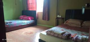 um quarto com duas camas num quarto em Tempasuk Homestay em Kota Belud