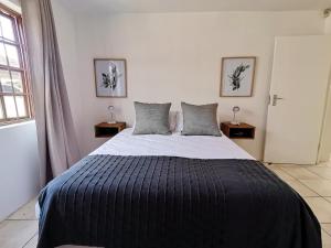 a bedroom with a large bed with two pillows at Beachfront apartment in a secure complex in Port Alfred