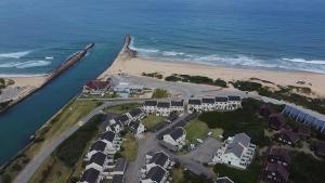 an aerial view of a beach with houses and the ocean at Beachfront apartment in a secure complex in Port Alfred
