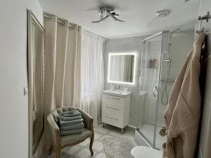 y baño con ducha, silla y lavamanos. en Louis & Elza Old Town Romantic apartments, en Wroclaw