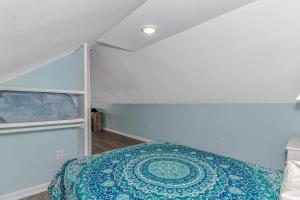 een slaapkamer met een bed met een blauw dekbed bij 125 Atlantic Avenue Unit G2 -Pet Friendly! Loft Apartment -Sleeps 2-4 guests! in Myrtle Beach