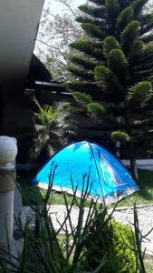 a blue umbrella sitting in the grass next to a house at Casa de Campo La Niebla in Tlalnelhuayocan