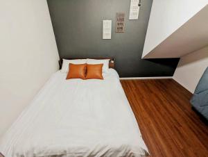 a bedroom with a bed with two orange pillows at Amber Iidabashi - Vacation STAY 87112v in Tokyo