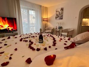 łóżko z butelką wina i różami w obiekcie Louis & Elza Old Town Romantic apartments we Wrocławiu