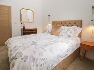 a bedroom with a bed and a mirror on the wall at Blacksmiths Cottage in Northallerton