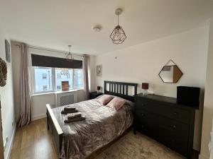a bedroom with a bed and a dresser and a window at 1 stop to London Bridge in London
