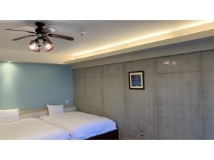 a bedroom with two beds and a ceiling fan at On the Beach Lue - Vacation STAY 91578v in Sesoko