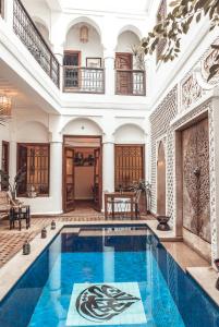 an indoor swimming pool in a building with a large house at Riad Dar Beldia and Spa in Marrakesh