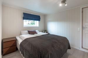 um quarto com uma cama grande e uma janela em Spacious modern apartment, close to nature em Tromsø