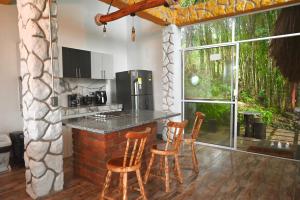 a kitchen with a counter with chairs and a table at Bambu chalet in Santa Rosa de Cabal