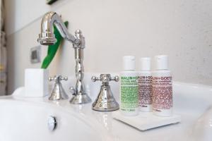 a bathroom sink with two bottles ofodorizers on it at The Fifteen Keys Hotel in Rome