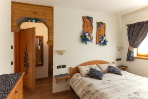 a bedroom with a bed and a door and a window at AL BORGO ANTICO residenza in Pinzolo