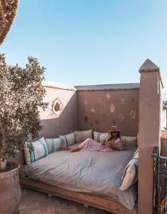 a woman laying on a bed on a patio at Riad Dar Beldia and Spa in Marrakesh
