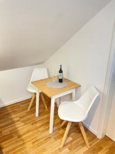 a table with two white chairs and a bottle of wine at Westendperle am Olympiastadion in Berlin