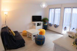 a living room with a couch and a tv at Cocooning chez Corinne , Gérardmer in Gérardmer