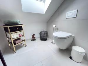 a white bathroom with a toilet and a shelf at Westendperle am Olympiastadion in Berlin