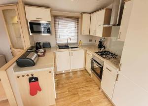 a kitchen with white cabinets and a red stocking on the counter at Lee Valley Sewardstone in Enfield Lock