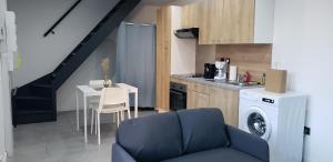 a kitchen with a washing machine next to a table at La Plume d'Or - Wifi - Parking Privé in Lens +10 photos