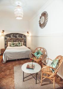 a bedroom with a bed and chairs and a table at Riad Dar Beldia and Spa in Marrakesh