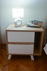 a desk with a lamp and a stack of books at MD apartman Vranje FREE PARKING in Vranje