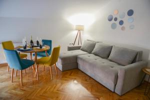 uma sala de estar com um sofá, uma mesa e cadeiras em MD apartman Vranje FREE PARKING em Vranje