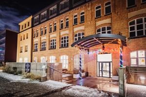 a brick building with an open door at night at FACTORY RESORT wellness & spa in Kołobrzeg
