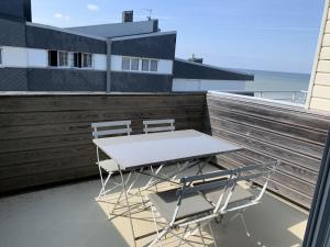 a table and two chairs sitting on a balcony at Appartement proche plage avec parking et balcon - FR-1-482-102 in Fort-Mahon-Plage