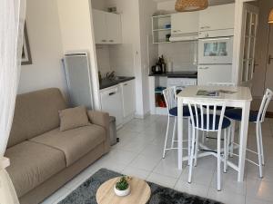 un salon avec un canapé et une table et une cuisine dans l'établissement Appartement proche plage avec parking et balcon - FR-1-482-102, à Fort-Mahon-Plage 6 autres photos