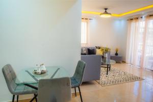 comedor con mesa de cristal y sillas en Luxury, cozy apartment Alma Rosa /15 min airport, en Los Tres Ojos de Agua