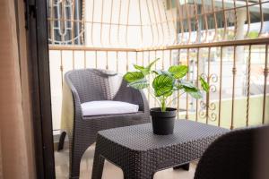 Un balcón con una mesa, una silla y una planta en Luxury, cozy apartment Alma Rosa /15 min airport, en Los Tres Ojos de Agua