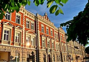 un grand bâtiment en briques avec beaucoup de fenêtres dans l'établissement Old Town Apartment Przemyśl, à Przemyśl