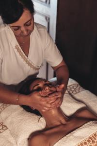 a woman sitting on a bed with her hands on her face at Riad Dar Beldia and Spa in Marrakesh