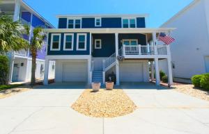 a house with an american flag in front of it at Oceanfront - Decks For Days in Kure Beach