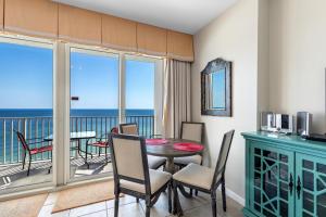 a dining room with a table and chairs and a balcony at Windemere 904 Pool Side Cabana Included! in Perdido Key