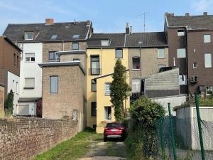 ein rotes Auto, das vor einigen Gebäuden parkt in der Unterkunft Leon Duren in Düren - Eifel